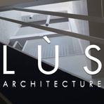 Lùs architecture écrit en blanc sur une image d'un immeuble