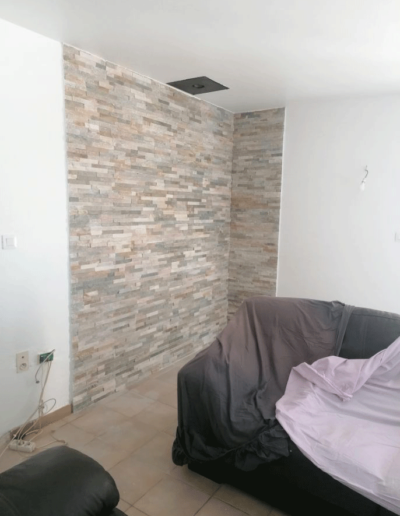 Salon repeint en blanc avec un angle de mur en plaquettes de parement